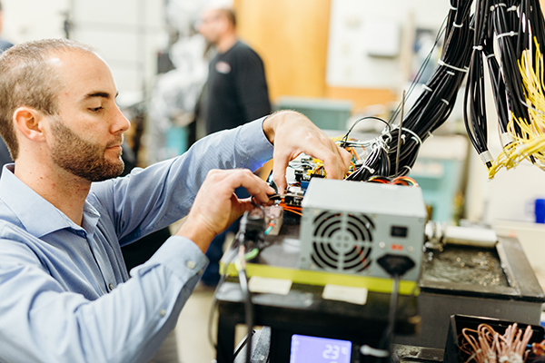 Person in a factory checking a piece of equipment